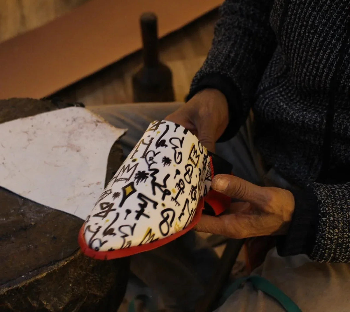 Maître artisan marocain façonnant une babouche en cuir faite main à Marrakech